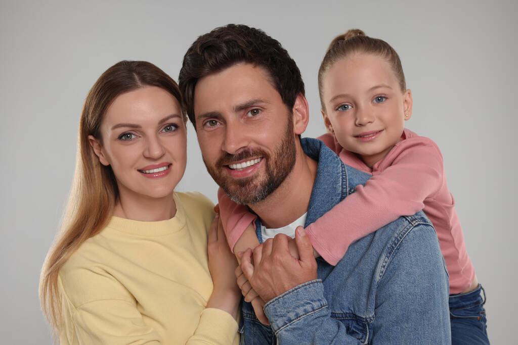 Onnellisen perheen muotokuva vaaleanharmaalla pohjalla - Valokuva, kuva
