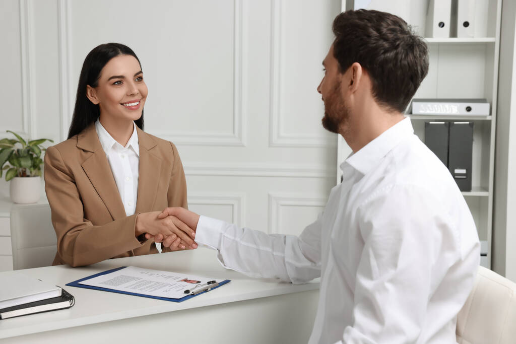 Human resources manager handen schudden met aanvrager tijdens job interview in kantoor - Foto, afbeelding