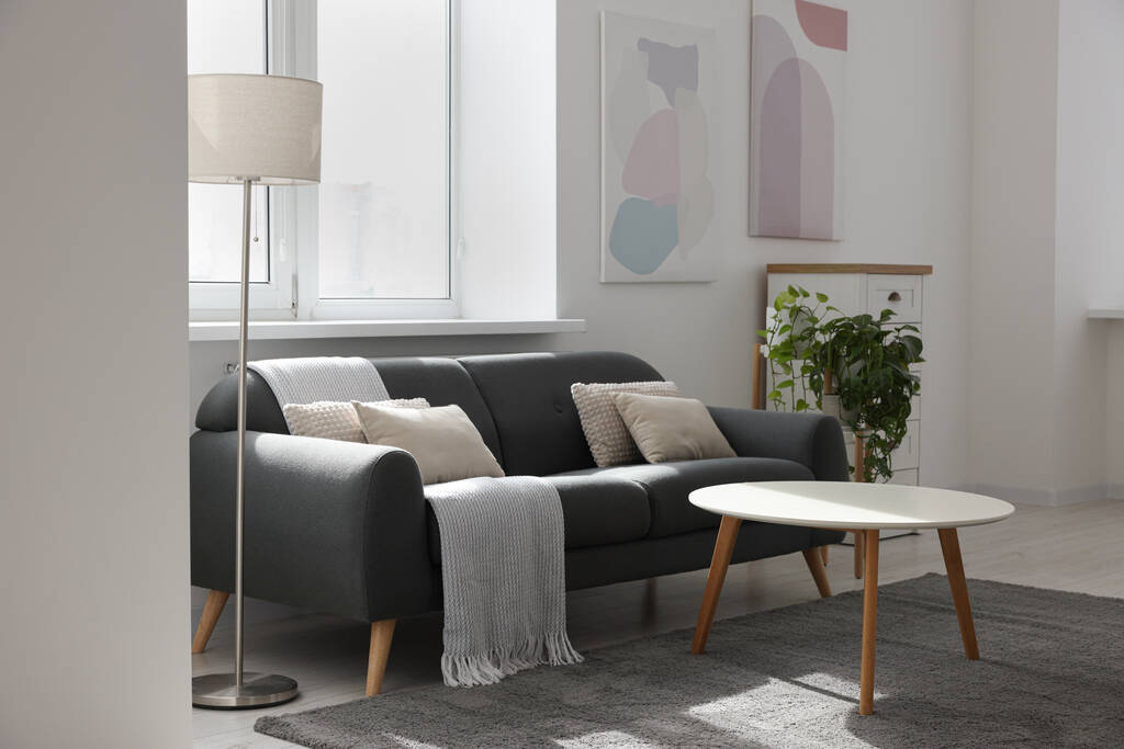 Tyylikäs olohuone harmaa sohva, valkoinen sohvapöytä ja lamppu. Sisustus - Valokuva, kuva