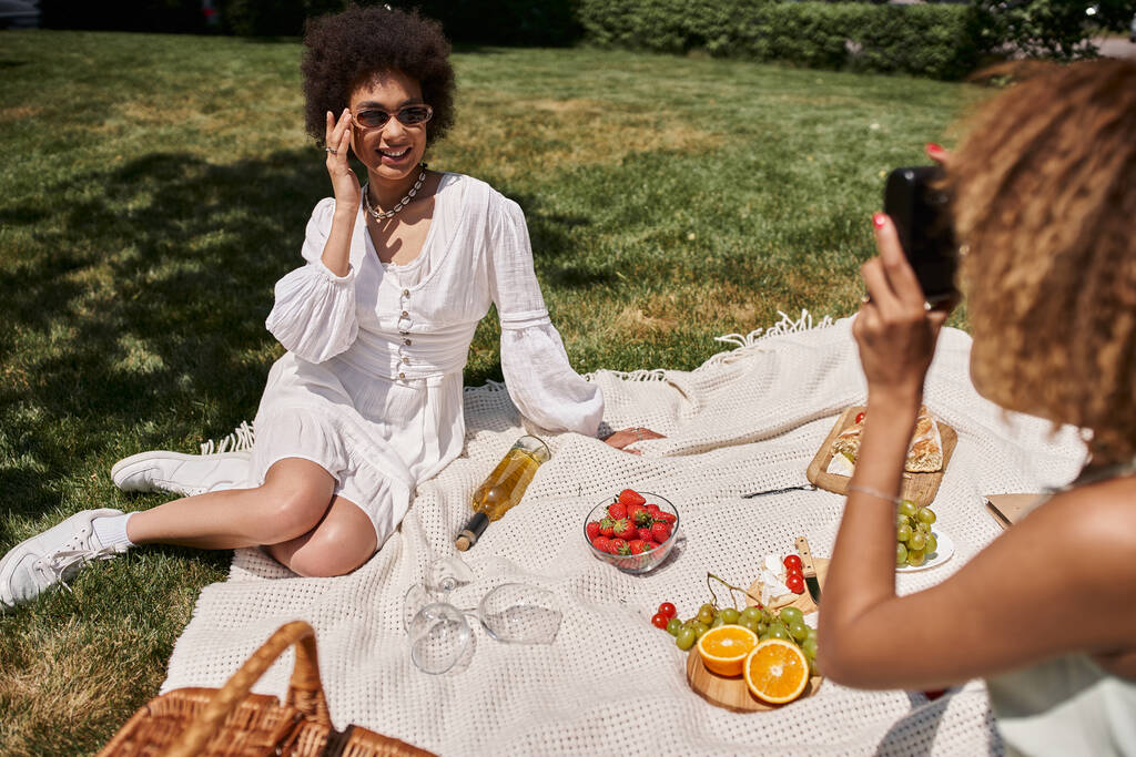 mulheres africanas jovens americanas relaxando em piquenique com frutas e vinho no parque de verão - Foto, Imagem