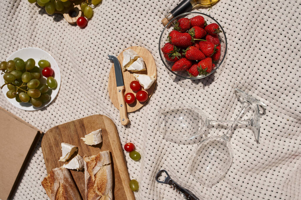 concepto de picnic de verano, fresas, uvas, tomates cherry, pan, queso, copas de vino, vista superior - Foto, Imagen