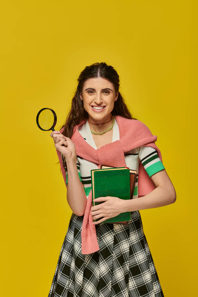 szczęśliwa młoda kobieta trzyma książki i lupę, zoom, odkrycie, student w stroju koledżu, uśmiech - Zdjęcie, obraz