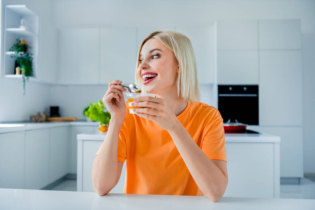 Фото великолепной веселой леди руки держать ложку йогурт наслаждаться мирным свободное время современная кухня дома внутри. - Фото, изображение