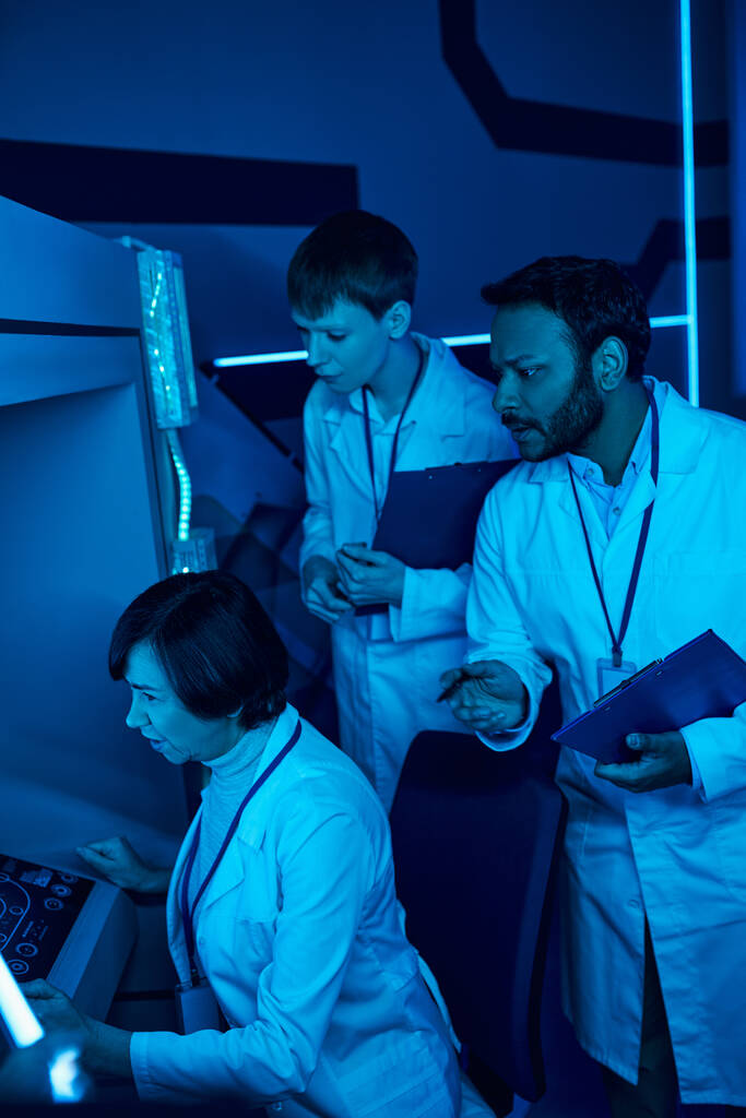 Exploring Tomorrow: Trzech naukowców współpracuje w Centrum Nauki w pobliżu futurystycznego komputera - Zdjęcie, obraz
