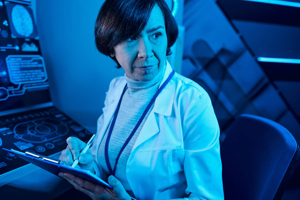Футуристична експертиза: старша жінка-науковець записує дані та споглядання в майбутньому науковому центрі - Фото, зображення