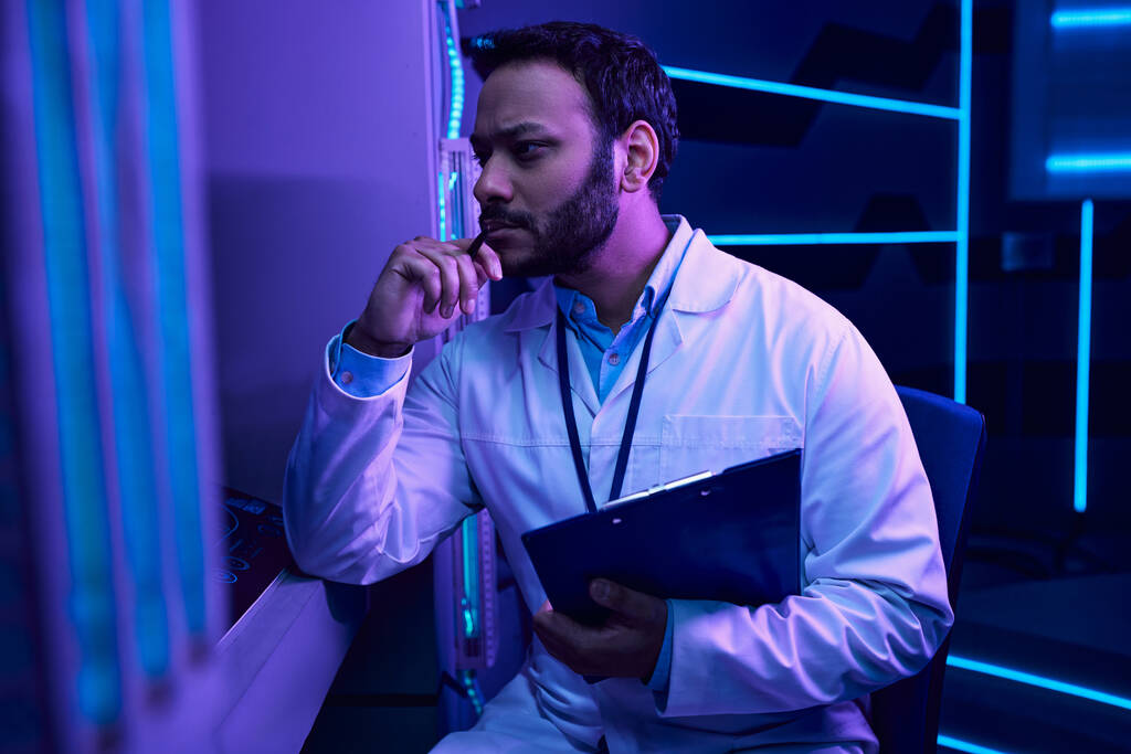 Réflexions futuristes : Un scientifique indien contemple une ambiance néon dans un centre scientifique - Photo, image