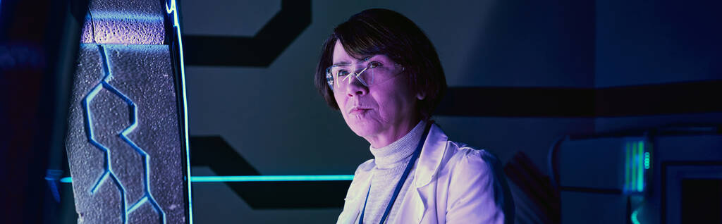 tulevaisuuden tiede, vakava keski-ikäinen nainen tiedemies futuristinen neon-valaistu teknologia napa, banneri - Valokuva, kuva
