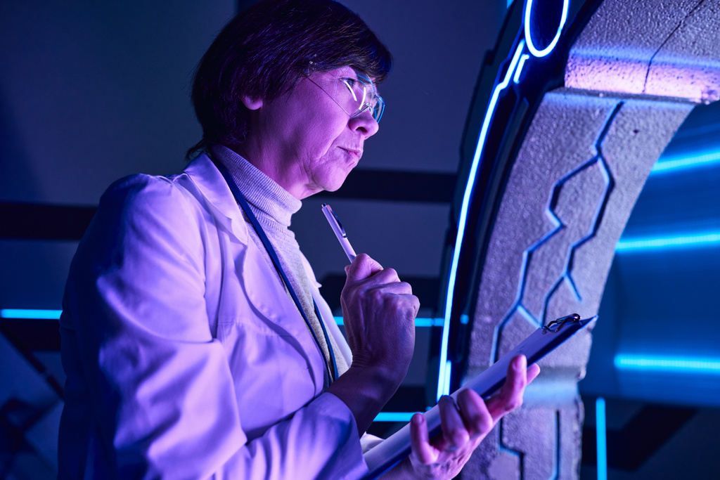 μελλοντικές τεχνολογίες, στοχαστική γυναίκα επιστήμονας με στυλό εξερεύνηση πειραματικού εξοπλισμού - Φωτογραφία, εικόνα