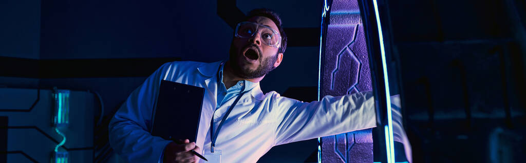 испуганный индийский ученый кричит, вкладывая руку в новое устройство в инновационном центре, баннер - Фото, изображение