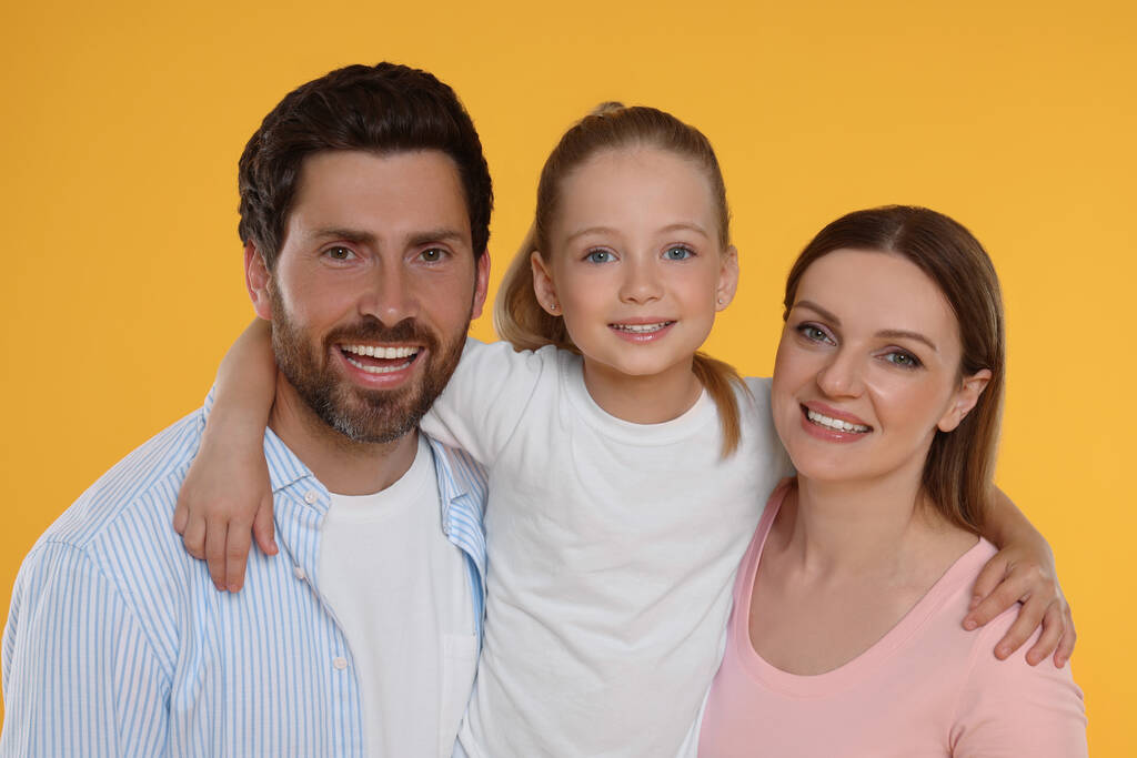Πορτρέτο της ευτυχισμένης οικογένειας σε πορτοκαλί φόντο - Φωτογραφία, εικόνα