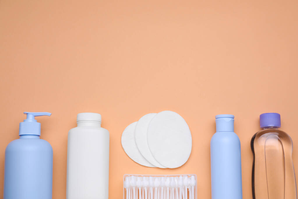 Flat lay composition with baby care products on pale orange background, space for text - Photo, Image
