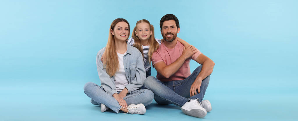 Onnellinen perhe, jolla on lapsi vaaleansinisellä taustalla. Bannerisuunnittelu - Valokuva, kuva