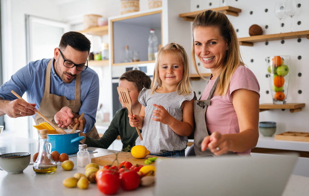 Felice giovane famiglia preparare cibo sano insieme in cucina. Persone felicità concetto di cottura - Foto, immagini