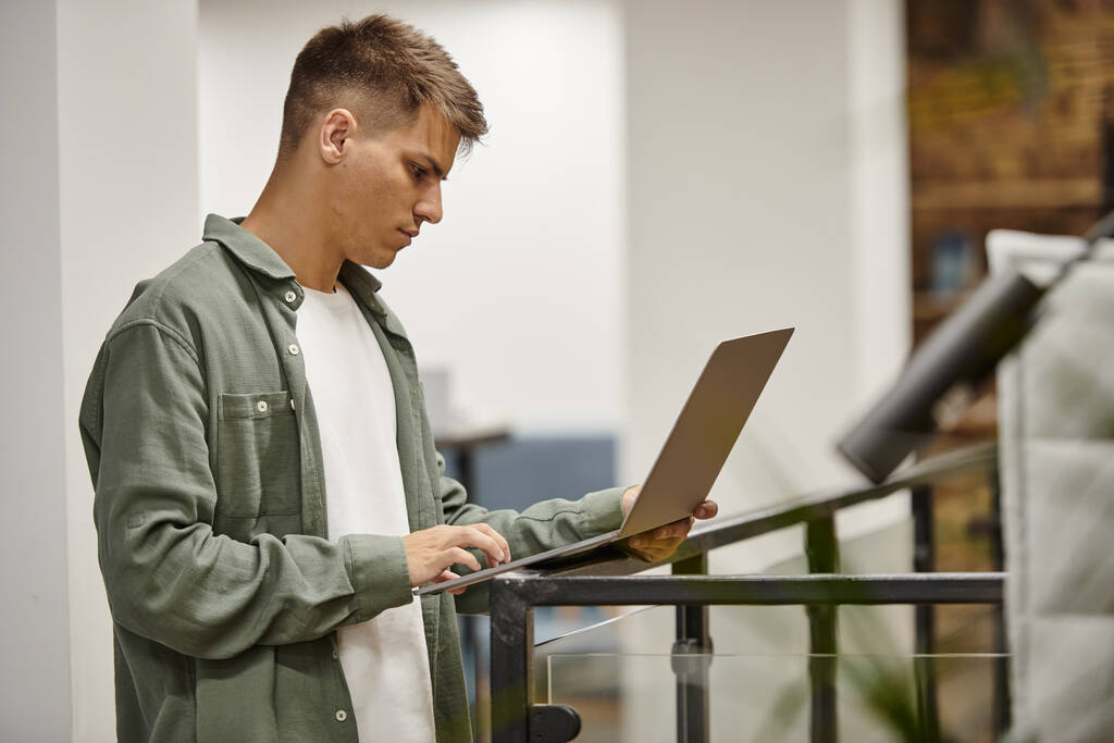 joven hombre de negocios que utiliza el ordenador portátil, coworking moderno, entorno de oficina, generación z, ideas de inicio - Foto, imagen