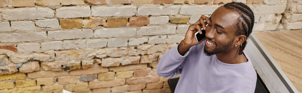 Genç Afro-Amerikan adam akıllı telefondan konuşuyor, birlikte çalışarak gülümsüyor, başlangıç, yatay afiş - Fotoğraf, Görsel