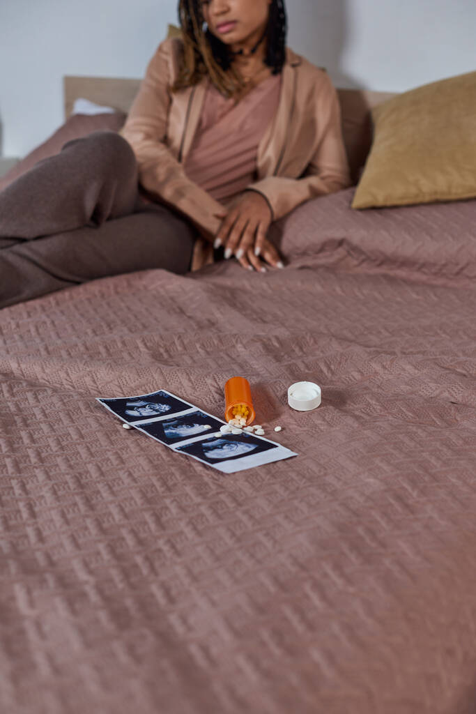 birth control pills near ultrasound photo, african american woman on bed, making decision, stress - Photo, Image