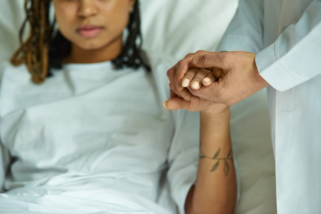 recortado, médico de la mano de mujer afroamericana en bata de hospital, sala privada, aborto espontáneo - Foto, Imagen
