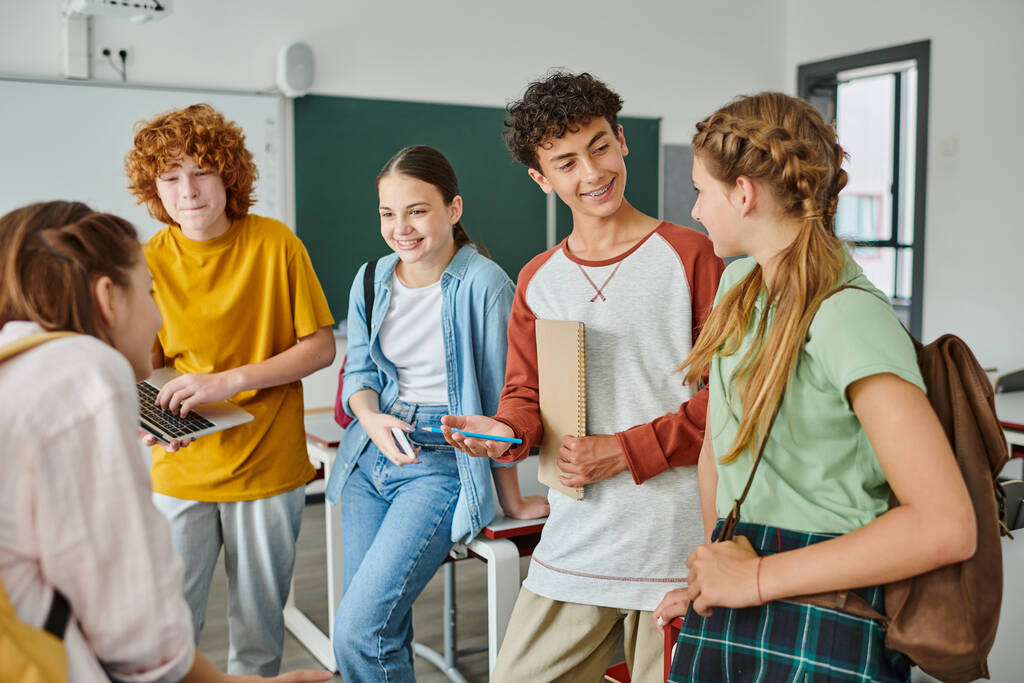happy teenagers talking in classroom, back to school, classmates communicating during school break - Photo, Image