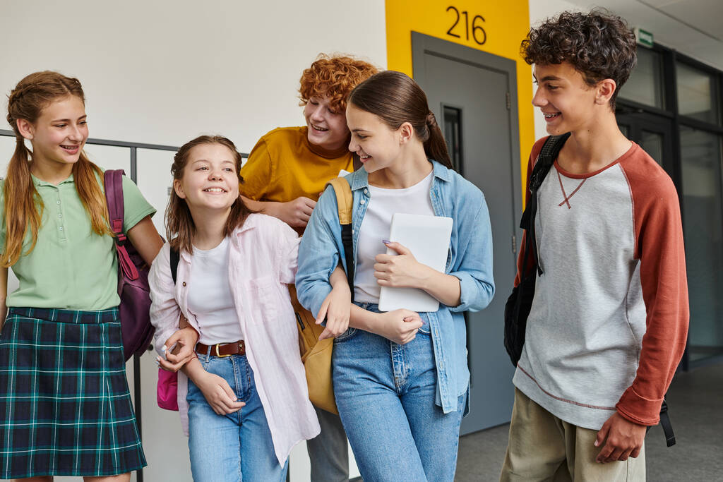 назад в школу, веселые одноклассники улыбаются в школьном коридоре, студенческая жизнь, друзья веселятся - Фото, изображение