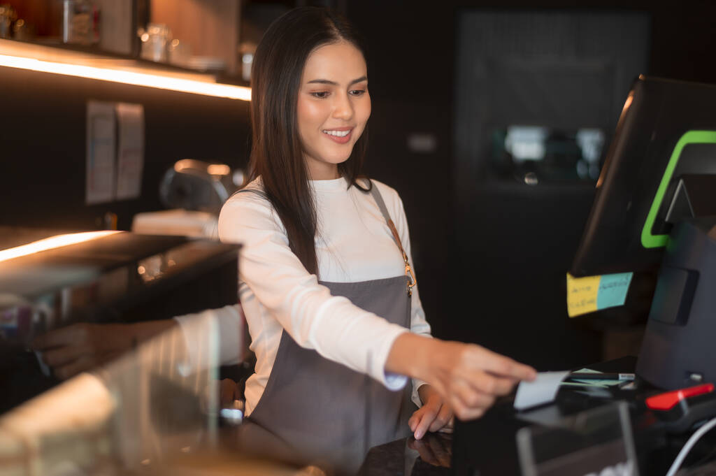 A young woman cashier working in modern coffee shop  - Photo, Image