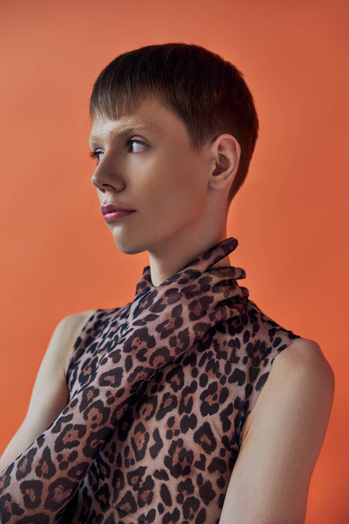 queer person, fashion concept, young man posing on orange backdrop, animal print, leopard print - Photo, Image