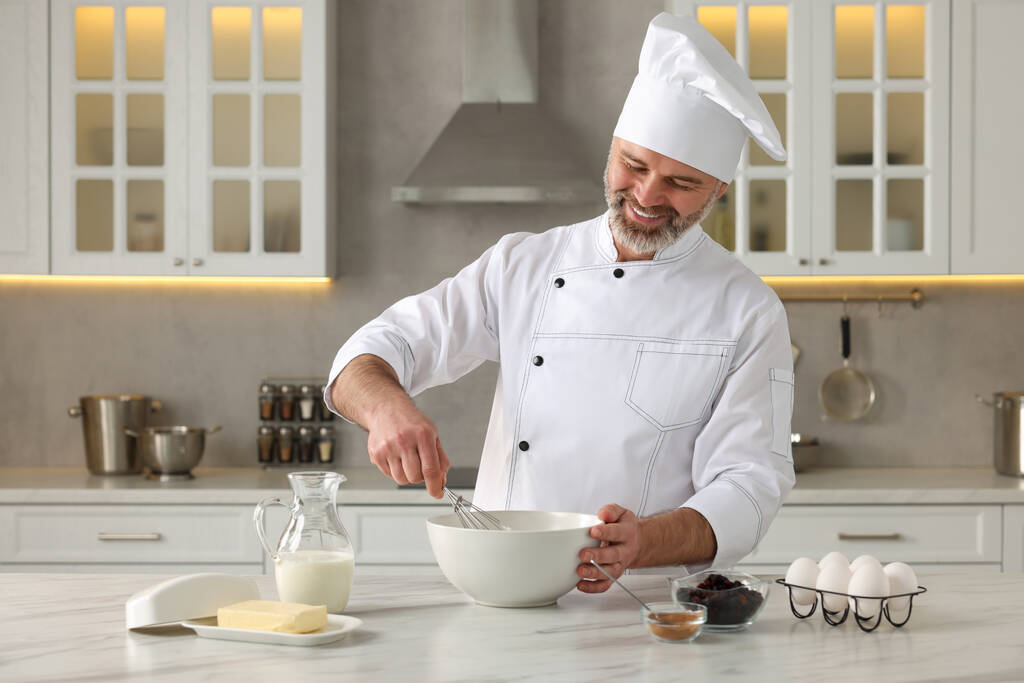 Професійний шеф-кухар робить тісто на білому мармуровому столі на кухні - Фото, зображення