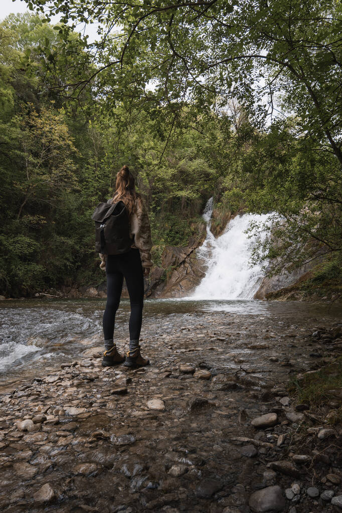 デリカ,アバラ,バスクのネヴァリオン川のポザ・デ・ロス・カバロスの滝を楽しんで立っている女性. - 写真・画像