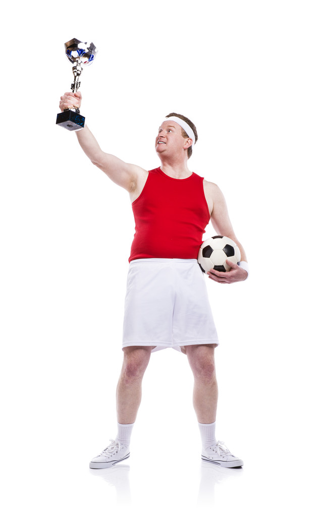 Αθλητικός τύπος με ένα τρόπαιο και το ποδόσφαιρο μπάλα. - Φωτογραφία, εικόνα