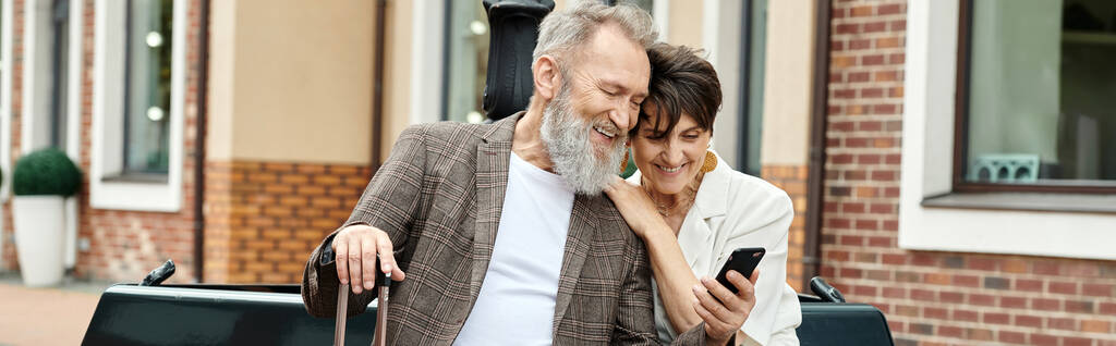 πανό, ηλικιωμένο ζευγάρι, ευτυχισμένος ηλικιωμένος άνδρας κρατώντας smartphone, κάθεται με γυναίκα χρησιμοποιώντας gadget - Φωτογραφία, εικόνα