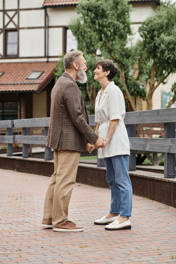 женщина и бородатый мужчина, держась за руки, свидание, старший роман, счастливая пожилая пара, полная длина - Фото, изображение