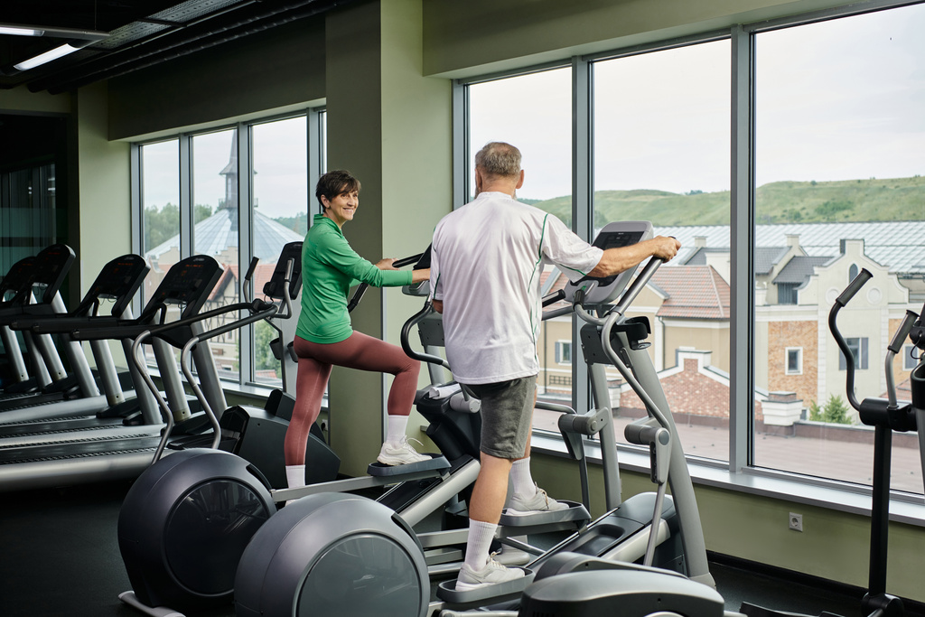 active seniors, cheerful woman looking at elderly man in gym, exercising together, senior couple - Photo, Image
