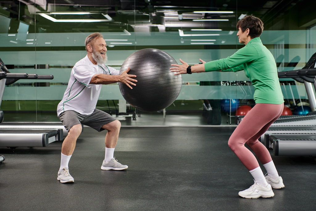szczęśliwy starzec mężczyzna i kobieta ćwiczenia z fitness piłka w siłowni, aktywnych seniorów, para sport - Zdjęcie, obraz