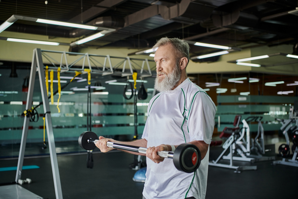 anziano atletico con barba che si esercita con bilanciere in palestra, anziano attivo, atleta, forza - Foto, immagini
