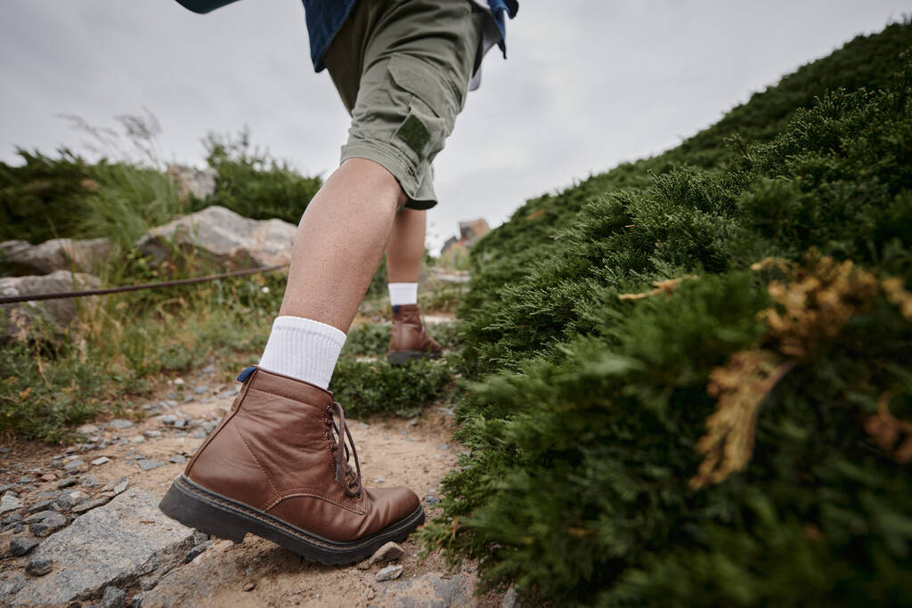 wild nature, cropped view of hiker walking in brown boots with white socks, adventure, traveler - Photo, Image