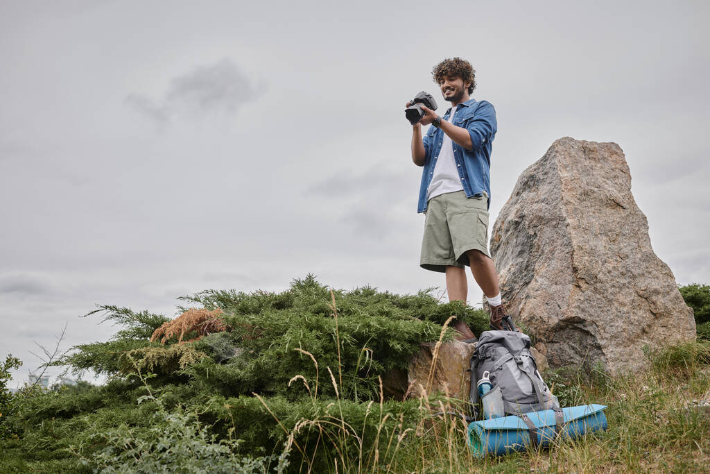 fotografie en natuurconcept, indiaanse toerist maakt foto 's op digitale camera en staat op rots - Foto, afbeelding