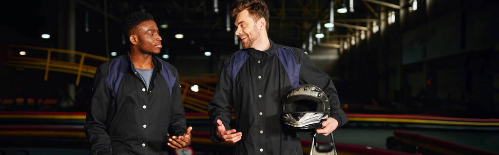 boldog multikulturális férfiak beszélgetnek belül Kart áramkör, Kart versenyzők kezében sisak, banner - Fotó, kép