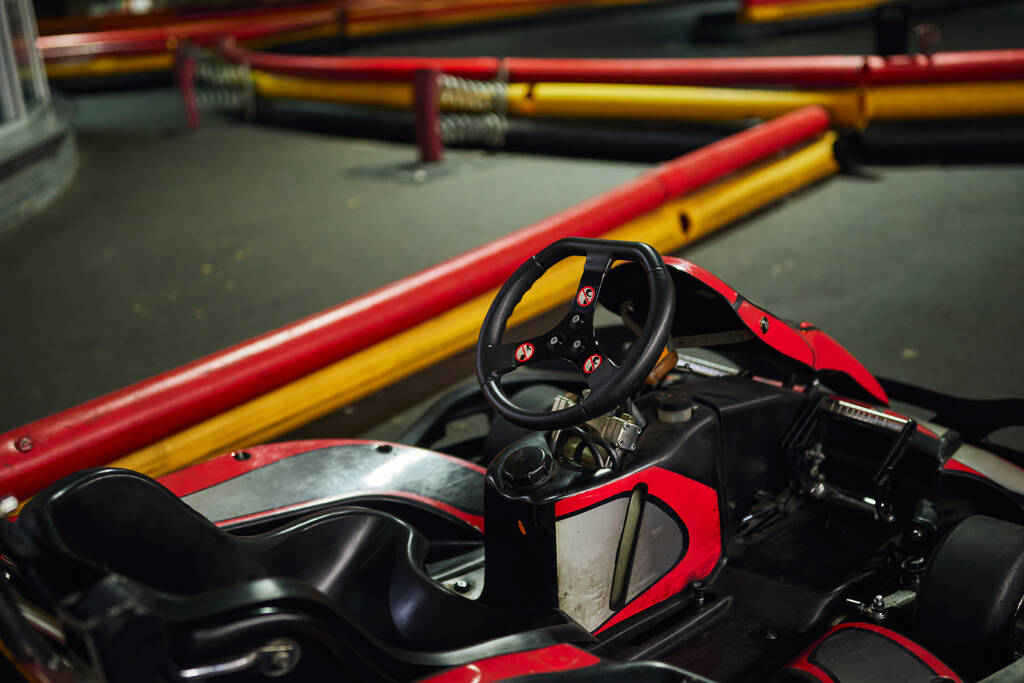 σχεδιασμός του κόκκινου αγωνιστικού αυτοκινήτου στο εσωτερικό του εσωτερικού κυκλώματος καρτ, μηχανοκίνητο αγωνιστικό όχημα, go cart, τιμόνι - Φωτογραφία, εικόνα