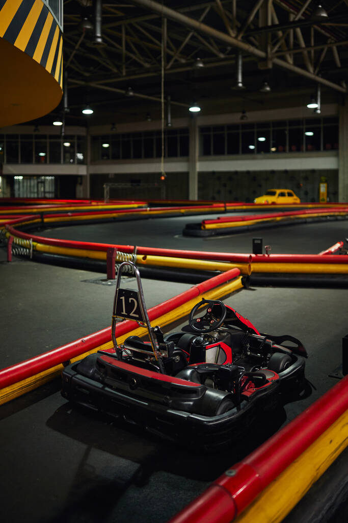 ontwerp van raceauto binnenkant van indoor kart circuit, rode motor race voertuig met nummer twaalf - Foto, afbeelding