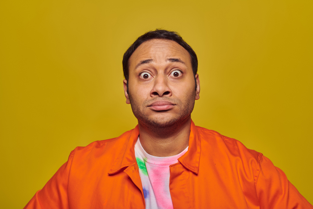 shocked indian man with eyes wide open looking at camera isolated on yellow, face expression - Photo, Image