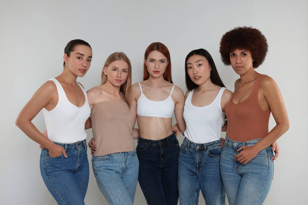 Ryhmä kauniita nuoria naisia vaaleanharmaa tausta - Valokuva, kuva
