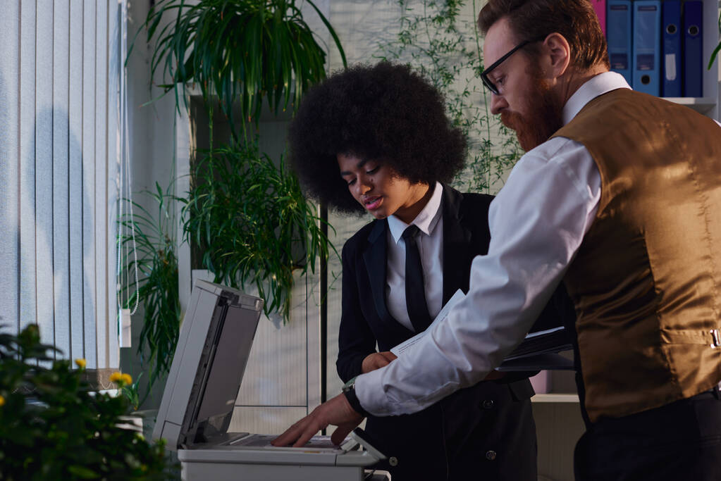 бородатий бізнесмен з документами, що пояснюють афроамериканську жінку як використовувати копіювальника в офісі - Фото, зображення