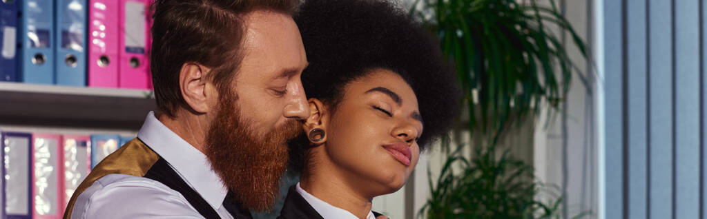 бородатый бизнесмен рядом с очаровательной африканской женщиной с закрытыми глазами, любовь в офисе, баннер - Фото, изображение