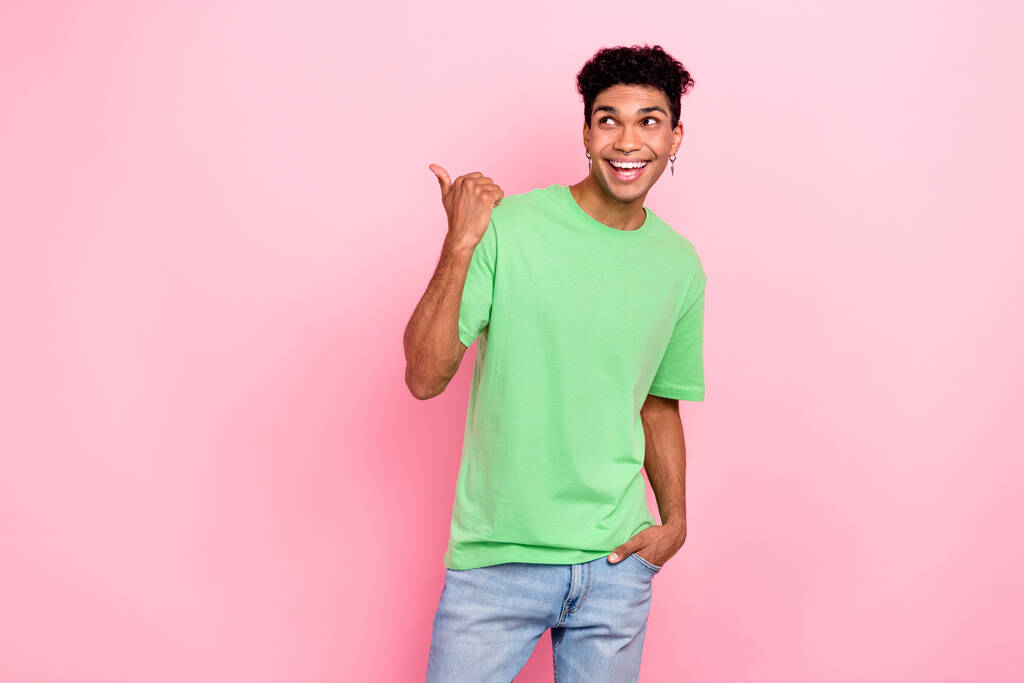 Foto de sonho animado cara usar t-shirt verde olhando mostrando polegar vazio espaço isolado cor de fundo rosa. - Foto, Imagem