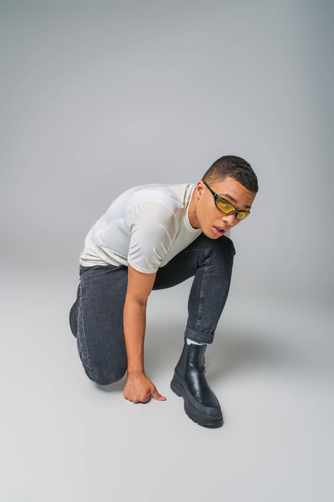 módní kupředu afroameričan v tričku, džínách a slunečních brýlích - Fotografie, Obrázek