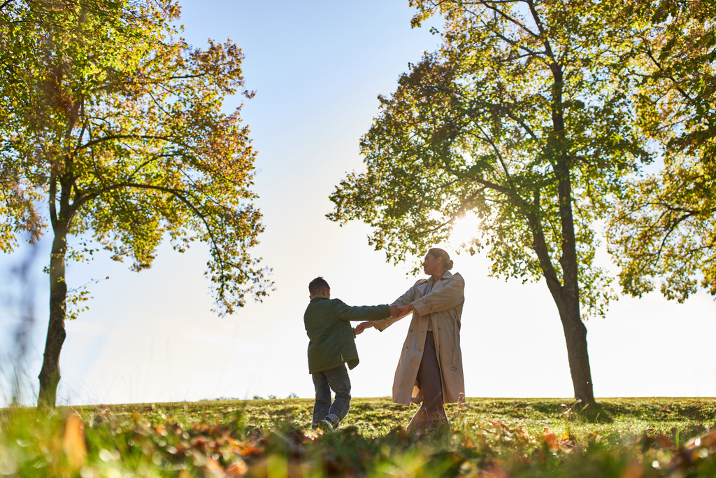 siluetti äiti ja lapsi kädestä syksyllä puistossa, syksyllä kausi, hauskaa, vapaus, tanssi - Valokuva, kuva