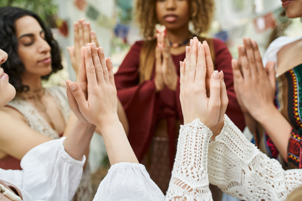 mujeres multiétnicas haciendo gesto de manos orantes mientras pasan tiempo al aire libre en el centro de retiro - Foto, imagen