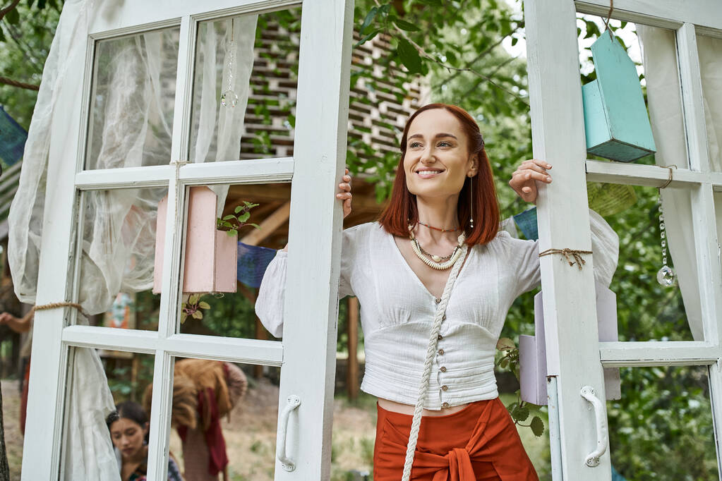 veselá a trendy zrzka žena stojící u dveří venku v centru ústupu - Fotografie, Obrázek