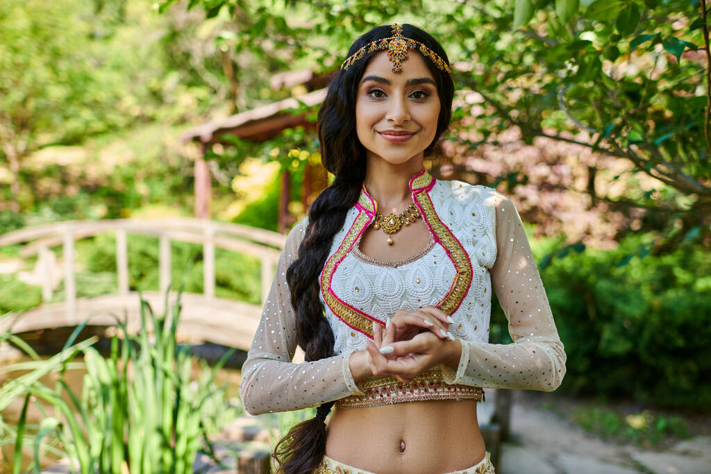 ritratto di attraente donna indiana in abbigliamento tradizionale sorridente alla macchina fotografica nel parco - Foto, immagini