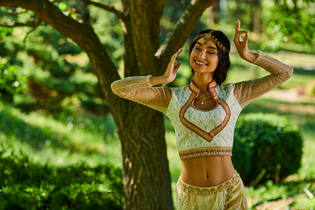 jeune et heureuse femme indienne en tenue authentique dansant dans le parc le jour ensoleillé, bonheur d'été - Photo, image
