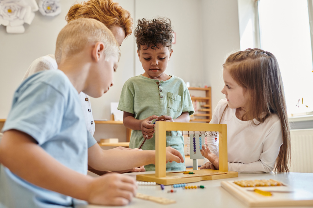 roztomilé děti při pohledu na africký americký chlapec hrát vzdělávací hru v Montessori škole, rozmanitost - Fotografie, Obrázek